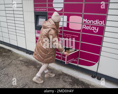 Loriol sur Drome, Frankreich - 14. Januar 2023: Abholung eines Pakets aus einem Mondial`Relay-Schließfach durch eine junge Frau. Schließfächer Mondial Relay. Pickup-Box. Stockfoto